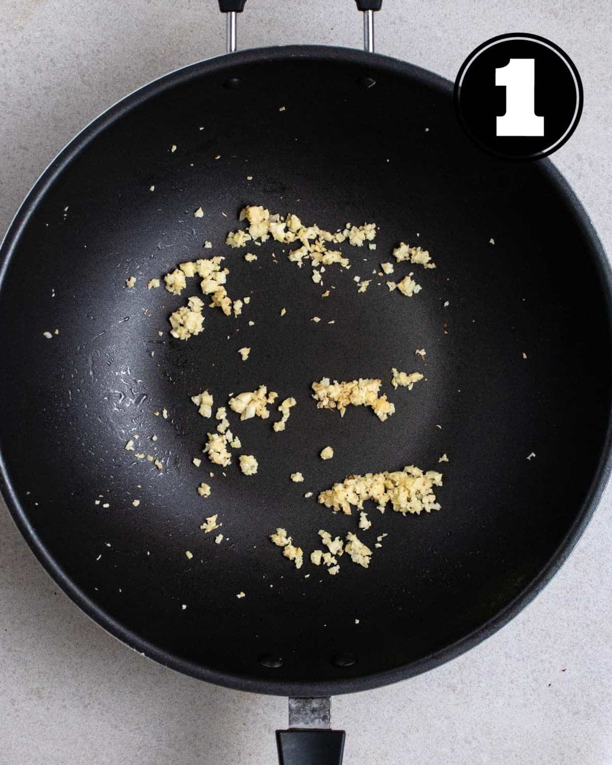 Cooked garlic and ginger in a wok.