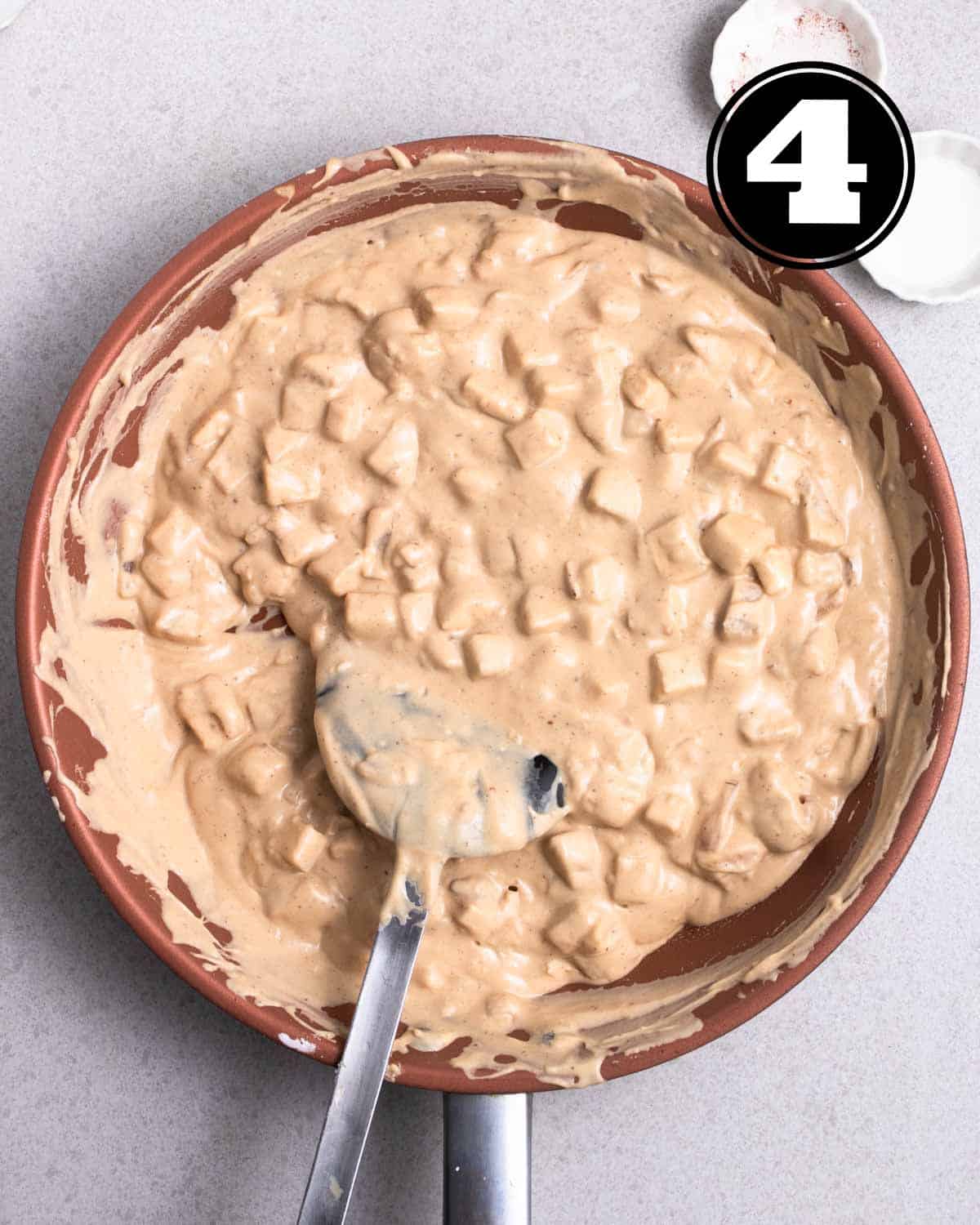 Thickened taro batter in a pan with a spatula beside.