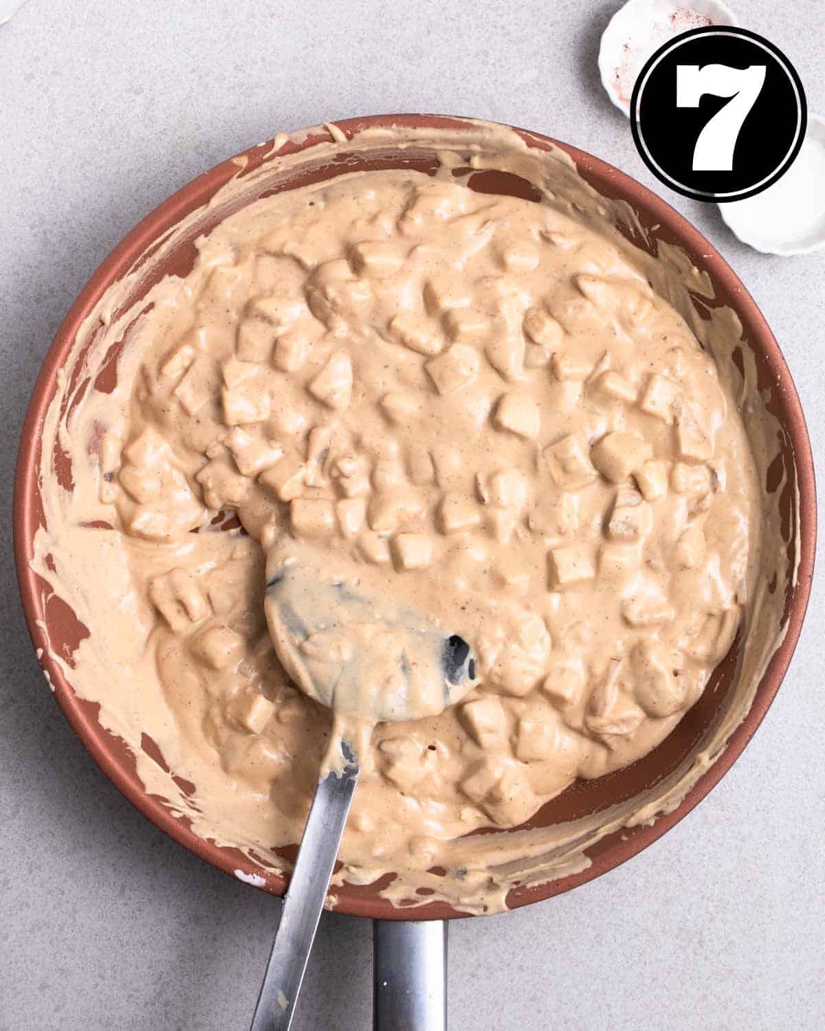 Batter for yam cake in a non-stick pan with a sillicon spatula beside.