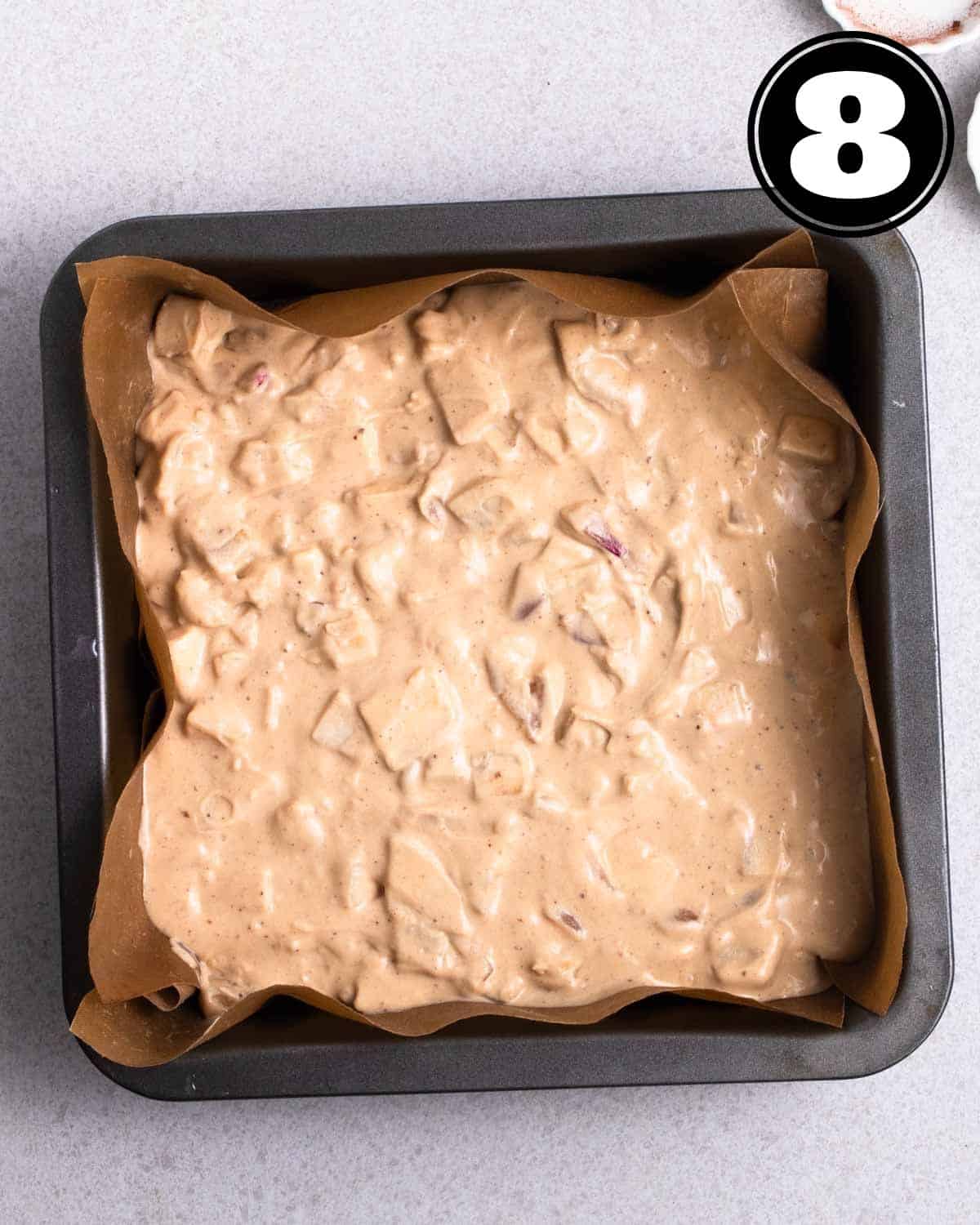 Yam cake batter in a square pan lined with parchment paper.