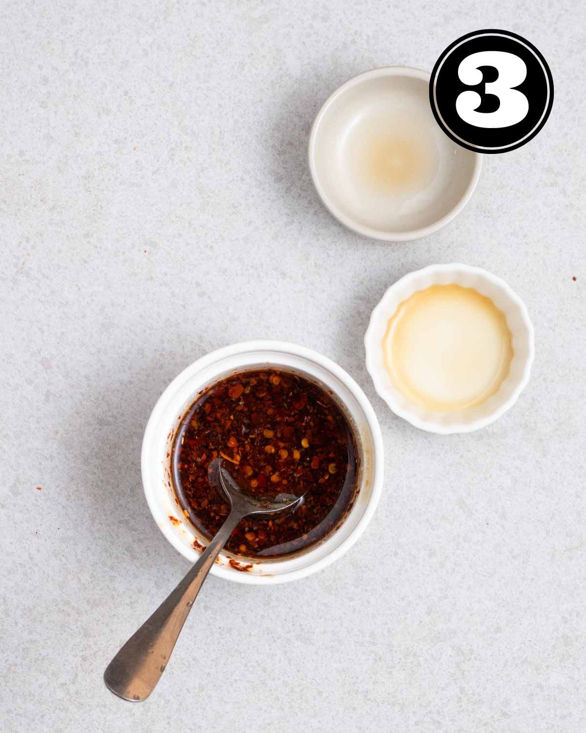 Stir-fry sauce in a ramekin with a teaspoon beside.