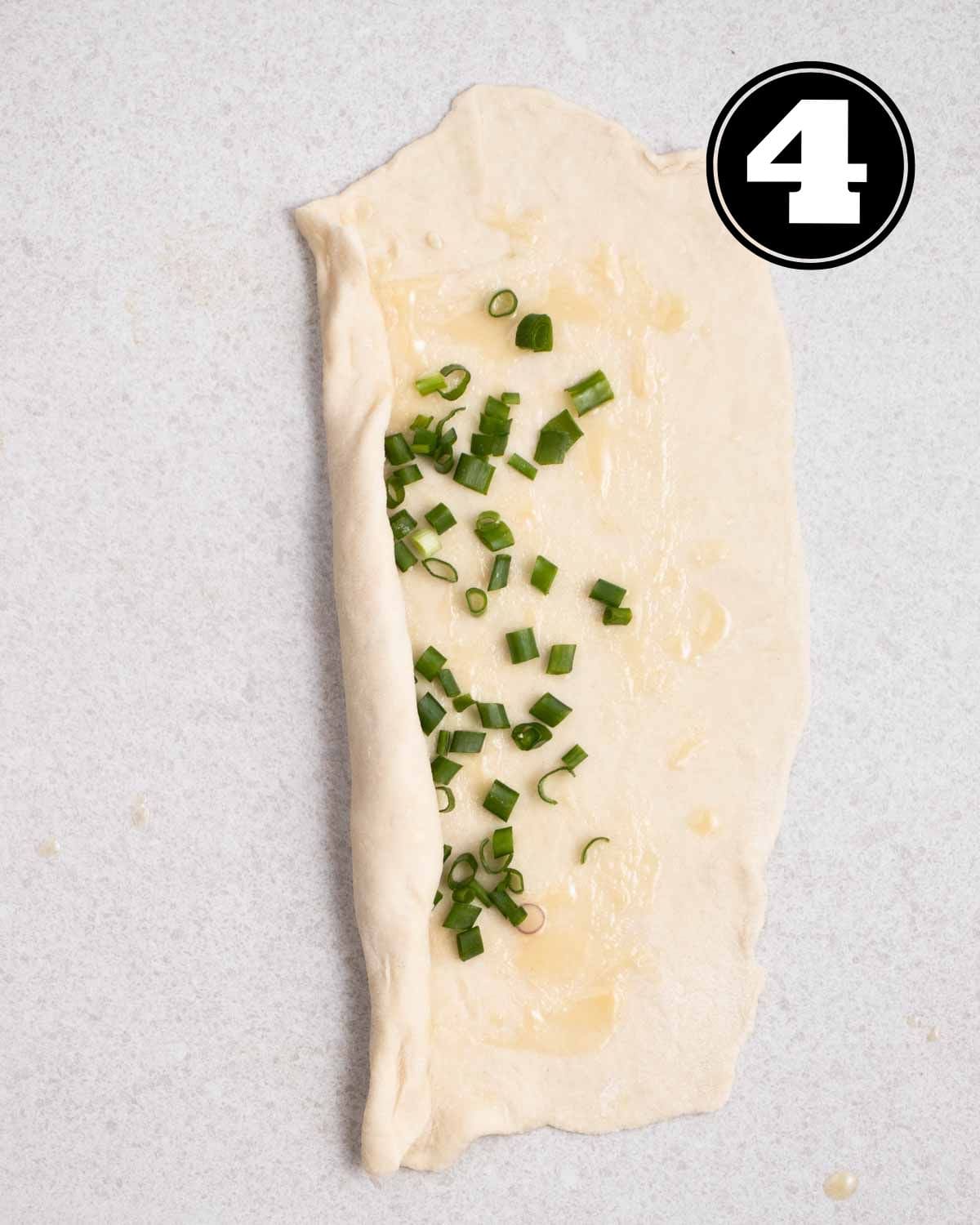 A partially rolled up scallion pancake dough.