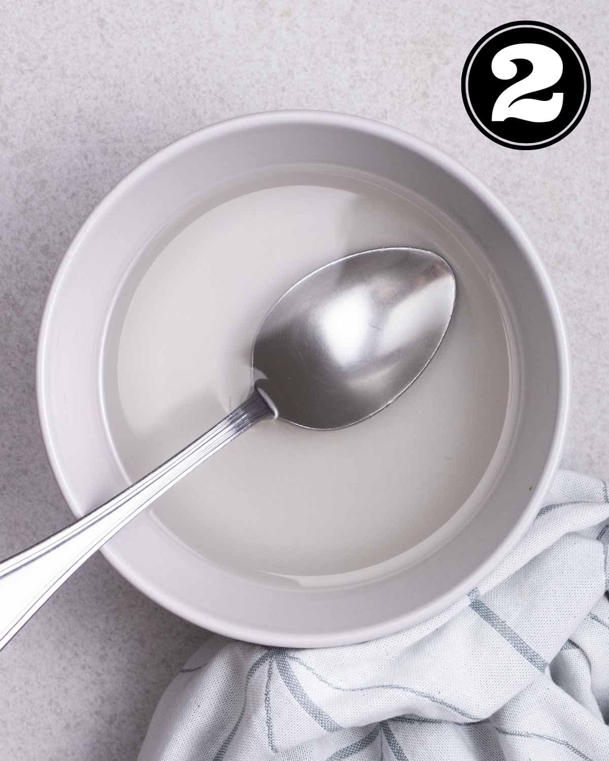 Sugar mixture in a bowl with a tablespoon beside.