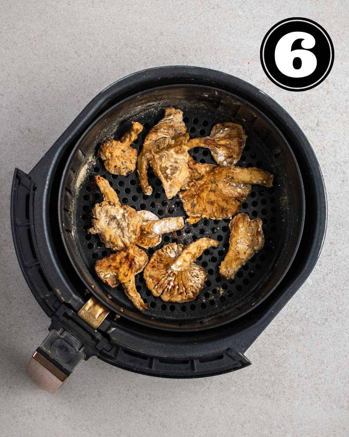 Cooked air fryer mushrooms in an air fryer container.