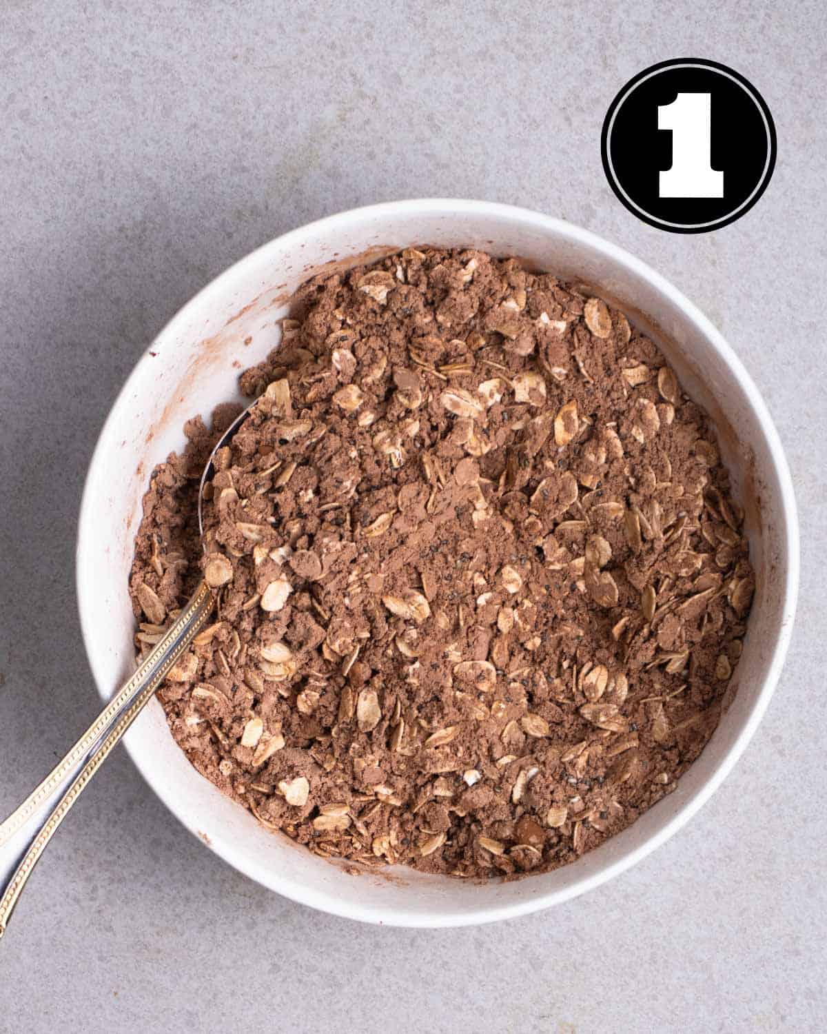Dry ingredients in a bowl with a spoon beside.
