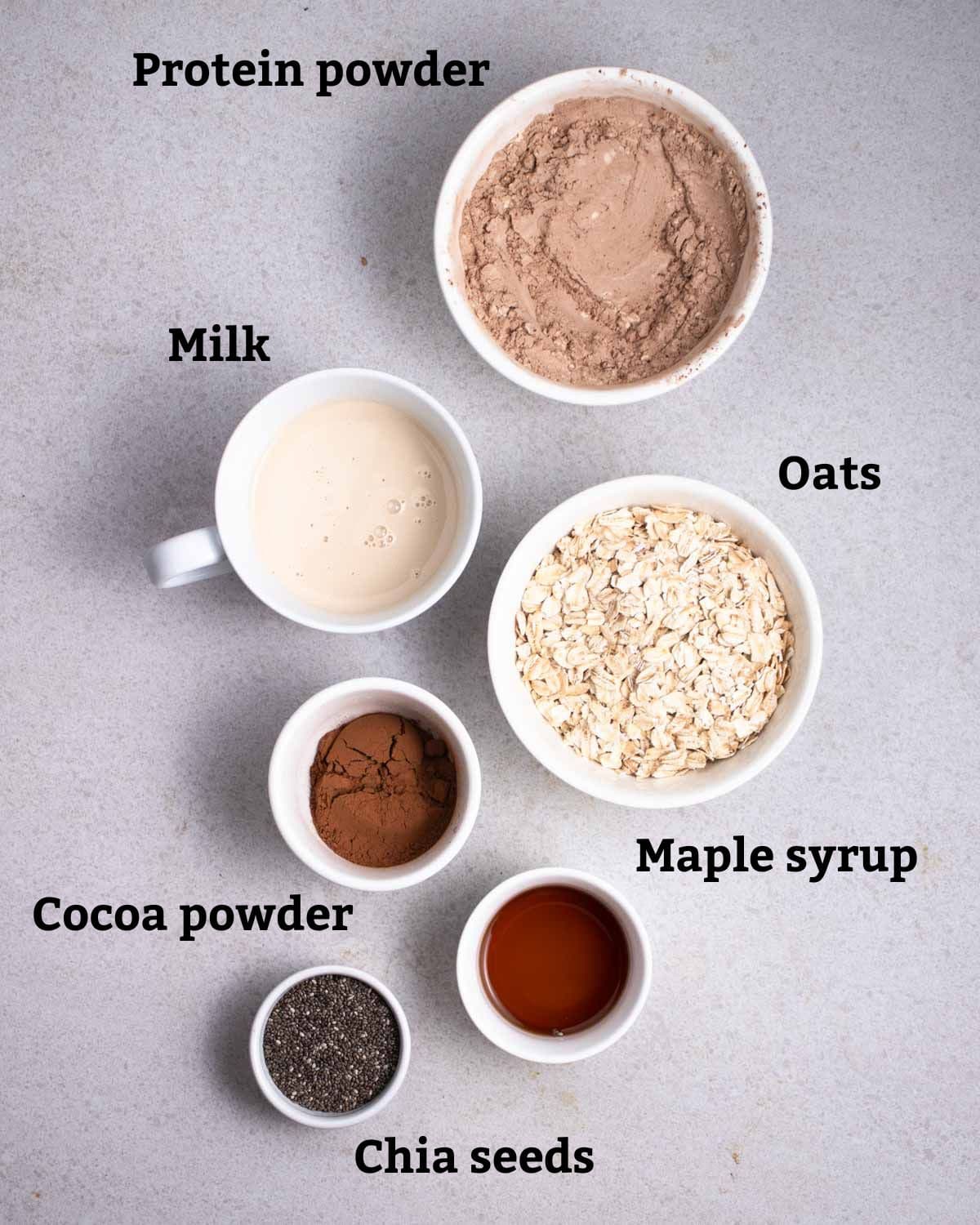 Ingredients needed like protein powder, oats, milk, cocoa powder, maple syrup and chia seeds.