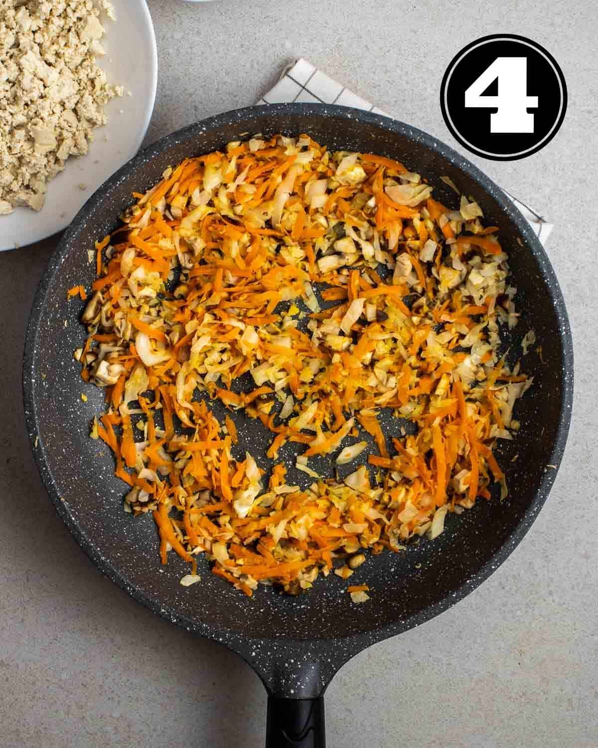 Sauteed vegetables in a pan with a plate of crumbled tofu beside.