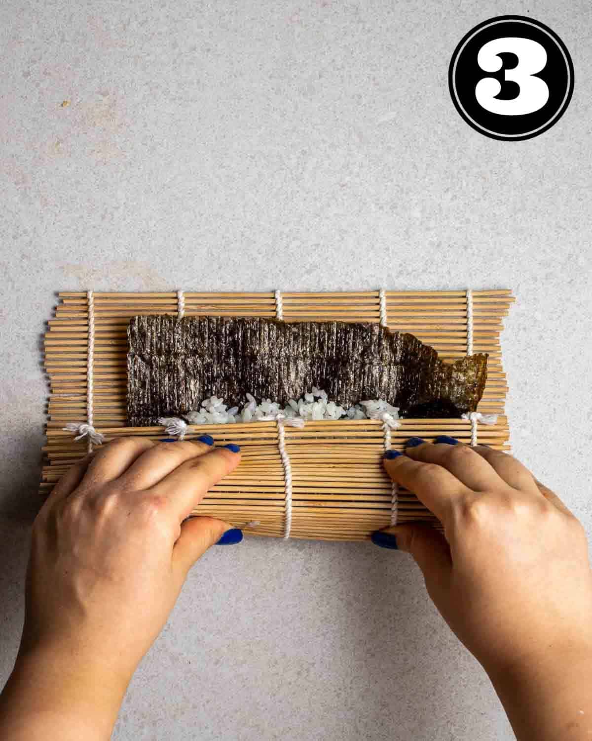 Rolling up a kimbap with a bamboo mat.