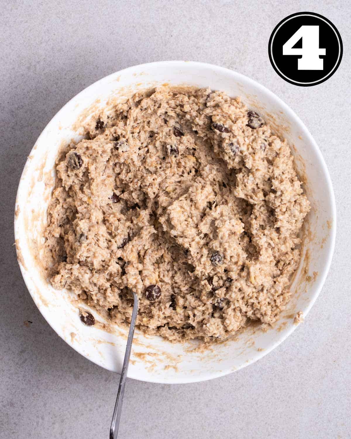 Cookie dough in a bowl with a fork beside.