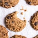 Cookies arranged on a parchment paper with a bite taken out of a cookie.
