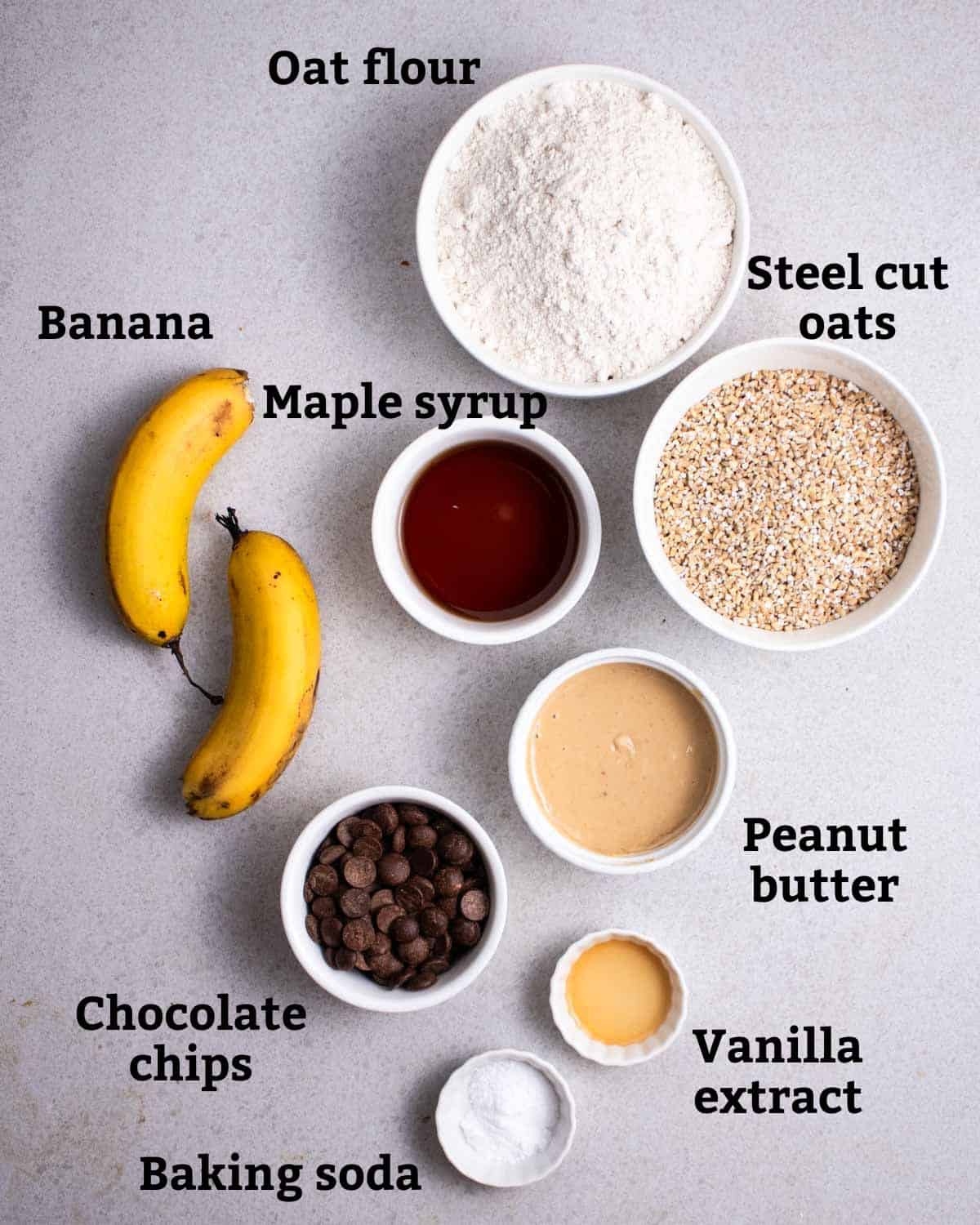 Ingredients needed like oat flour, oats, banana, maple syrup, peanut butter, vanilla extract, chocolate chips, and baking soda.