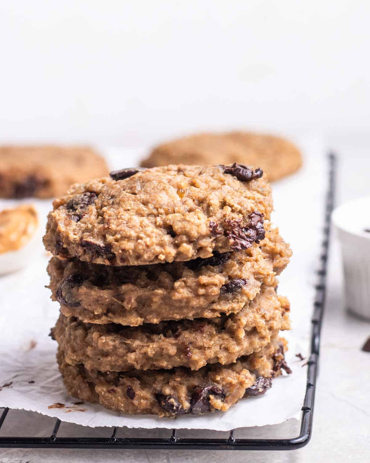 A stack of steel cut oats cookies on a baking tray lined with parchment paper.