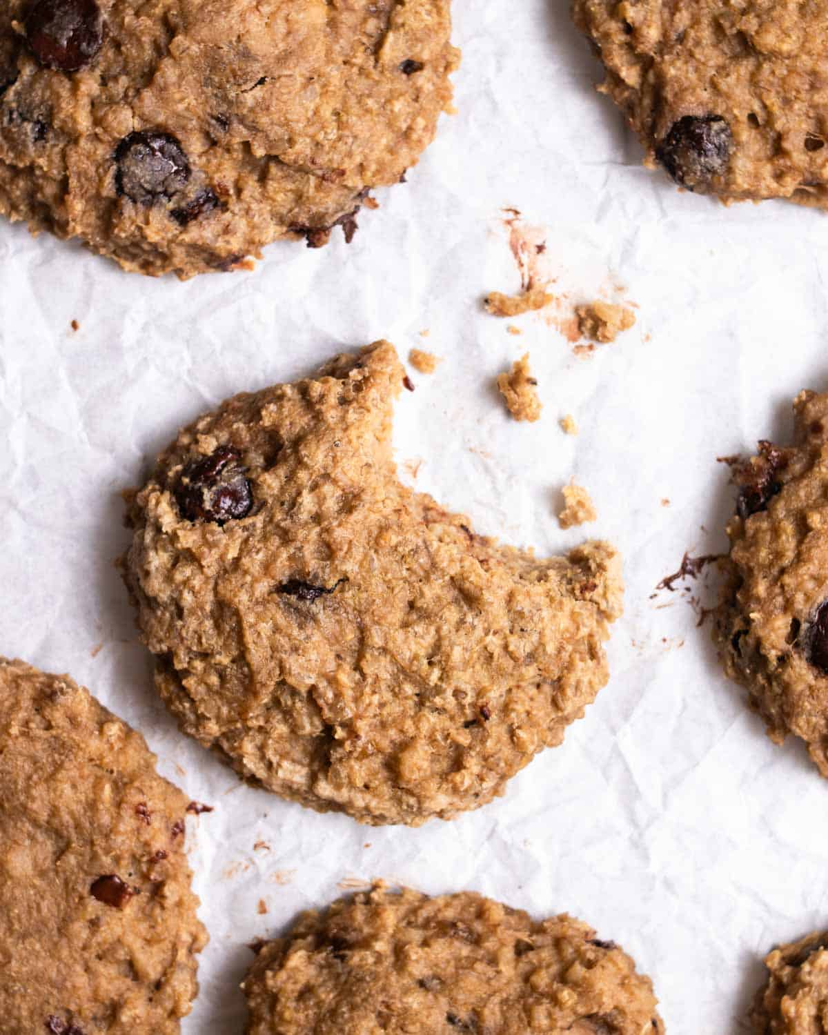 Cookies arranged on a parchment paper with a bite taken out of one of the cookie.