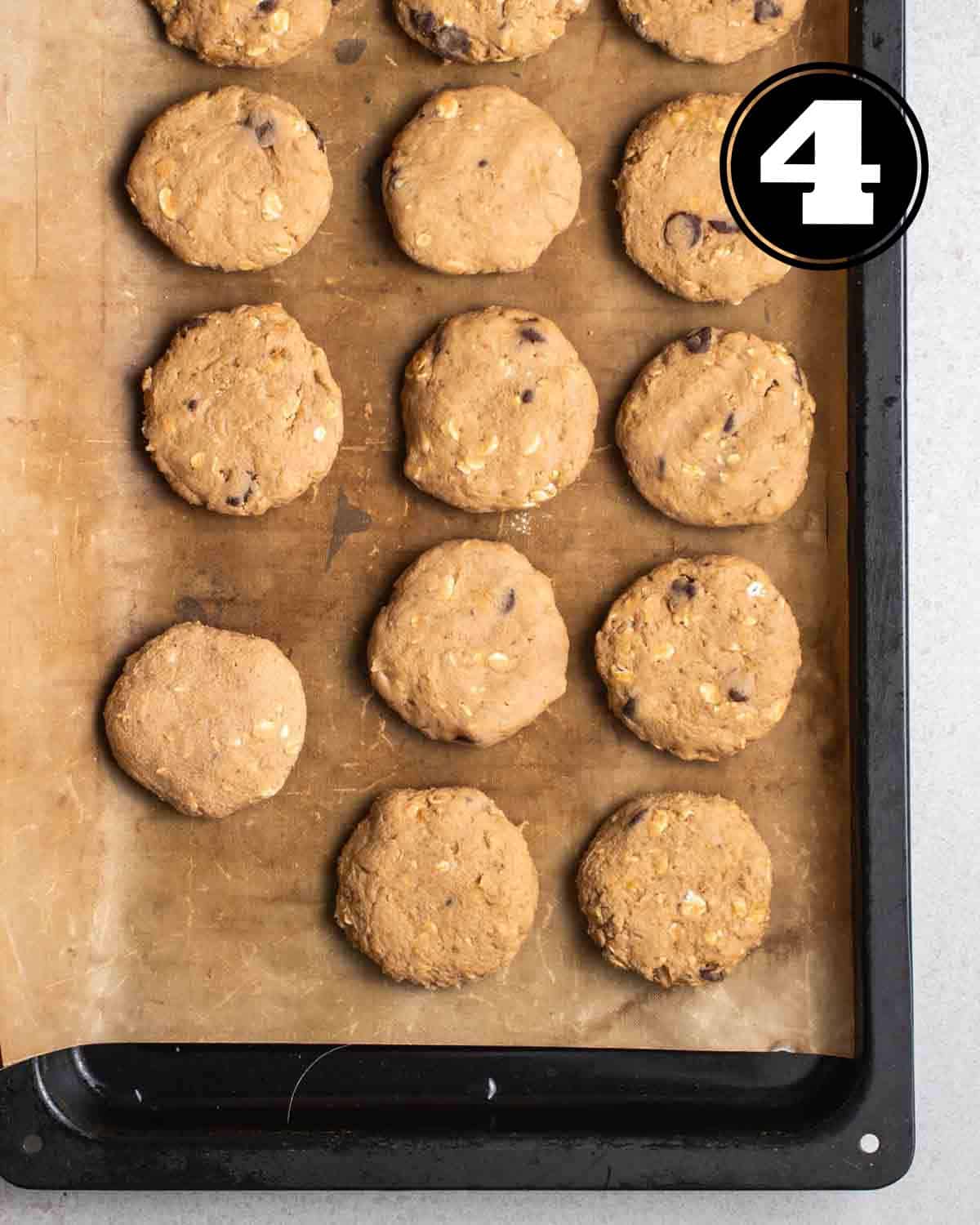 Shaped, unbaked cookies in a lined black baking tray.