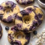 5 blueberry donuts arranged on a white board.