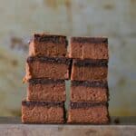 2 stacks of fudge bars on a wooden board.