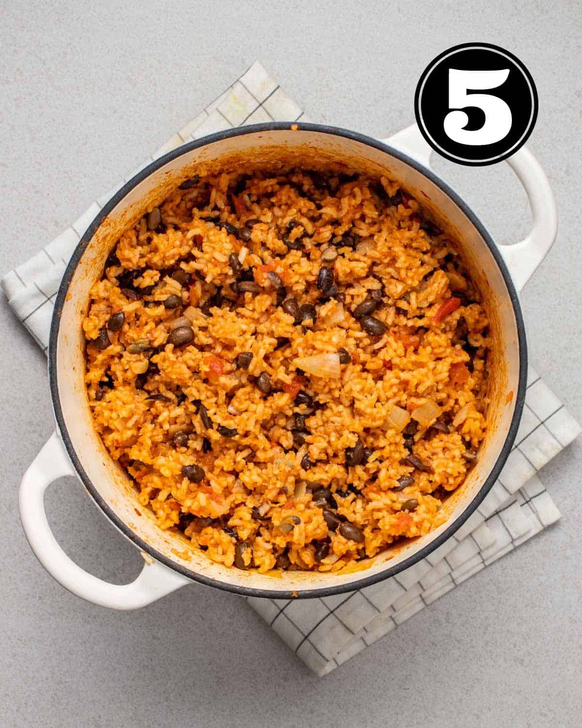 A pot of cooked rice and black beans in a Dutch oven.