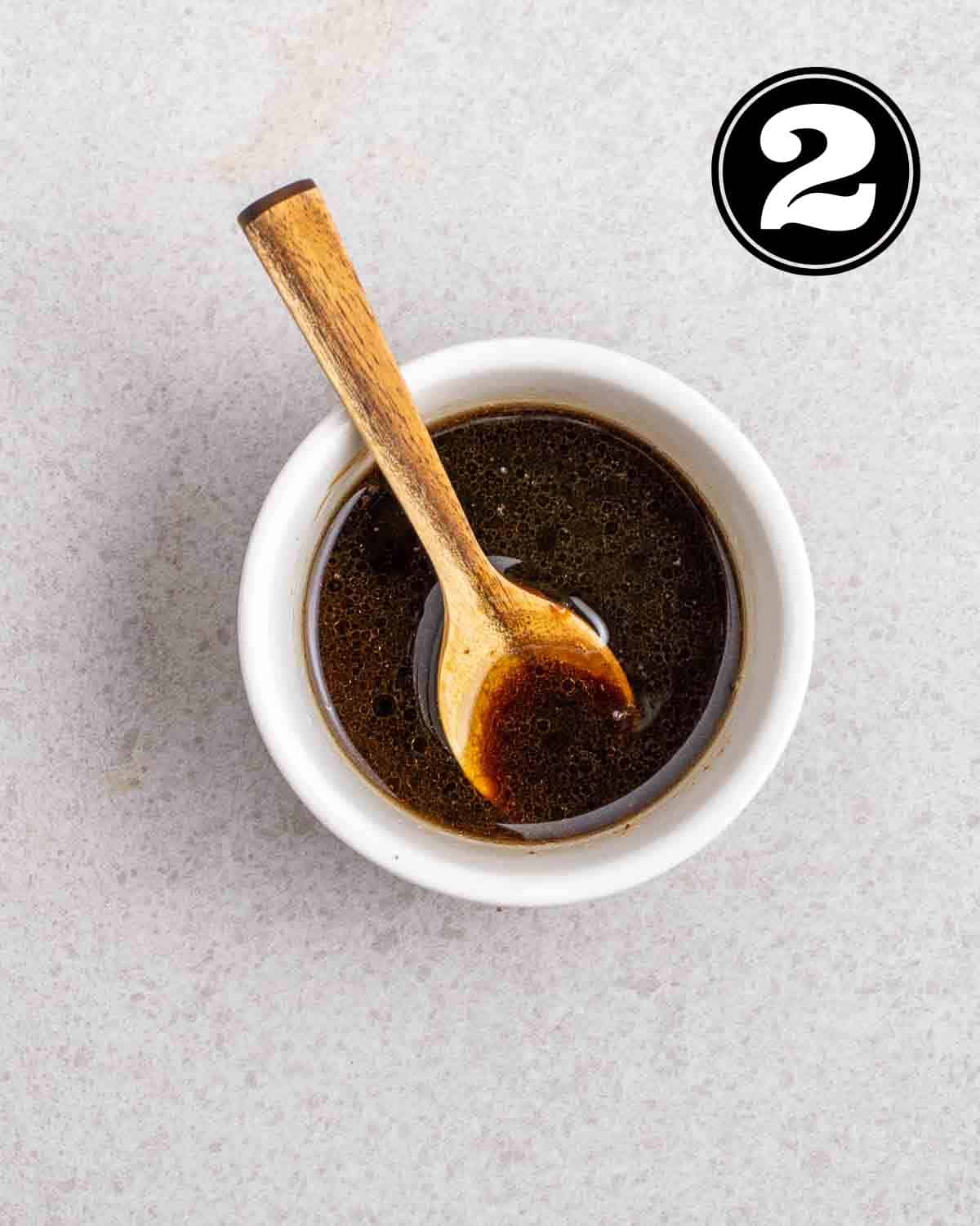Dressing for wakame salad in a ramekin with a wooden spoon beside.
