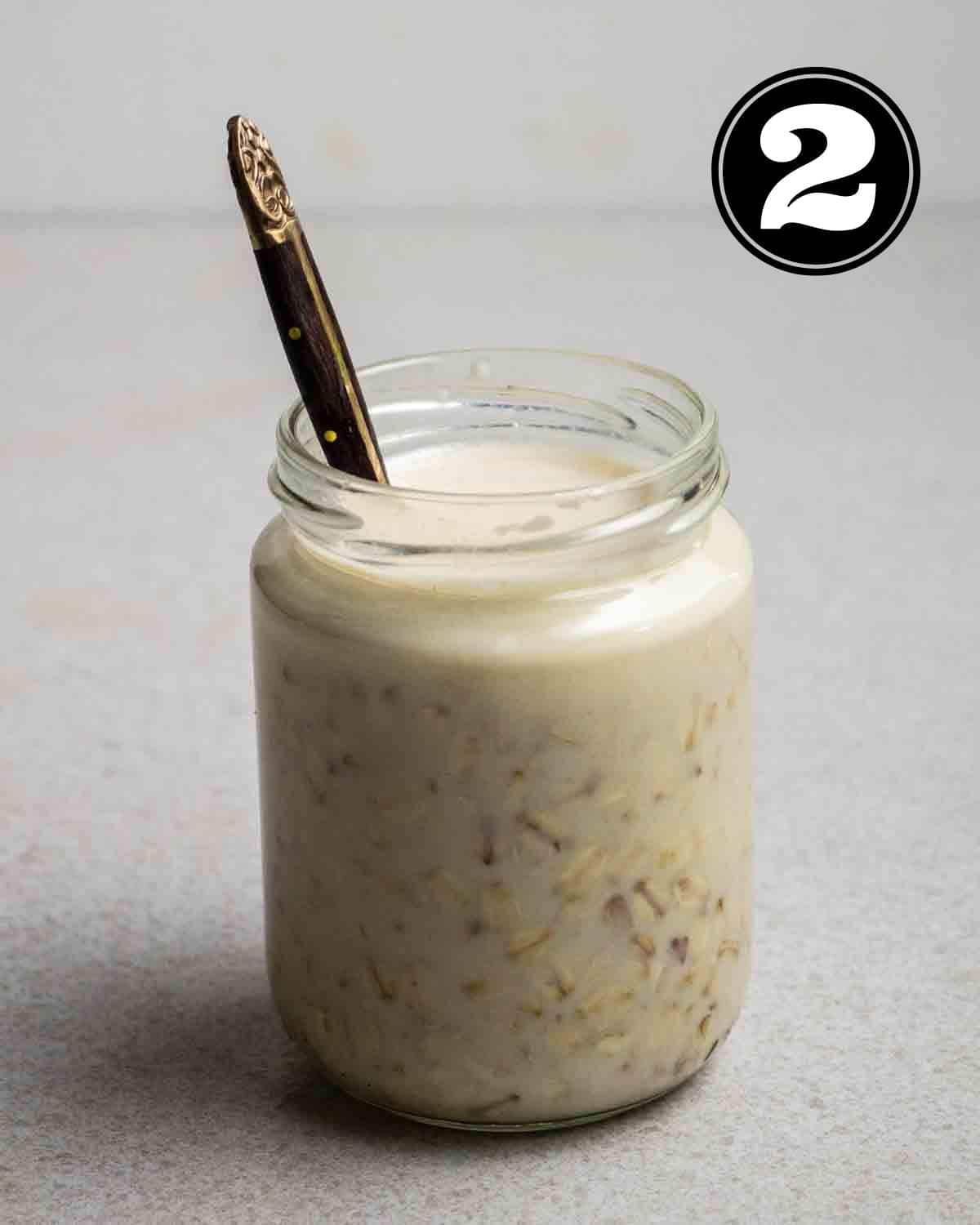 A jar of overnight oats with a teaspoon beside.