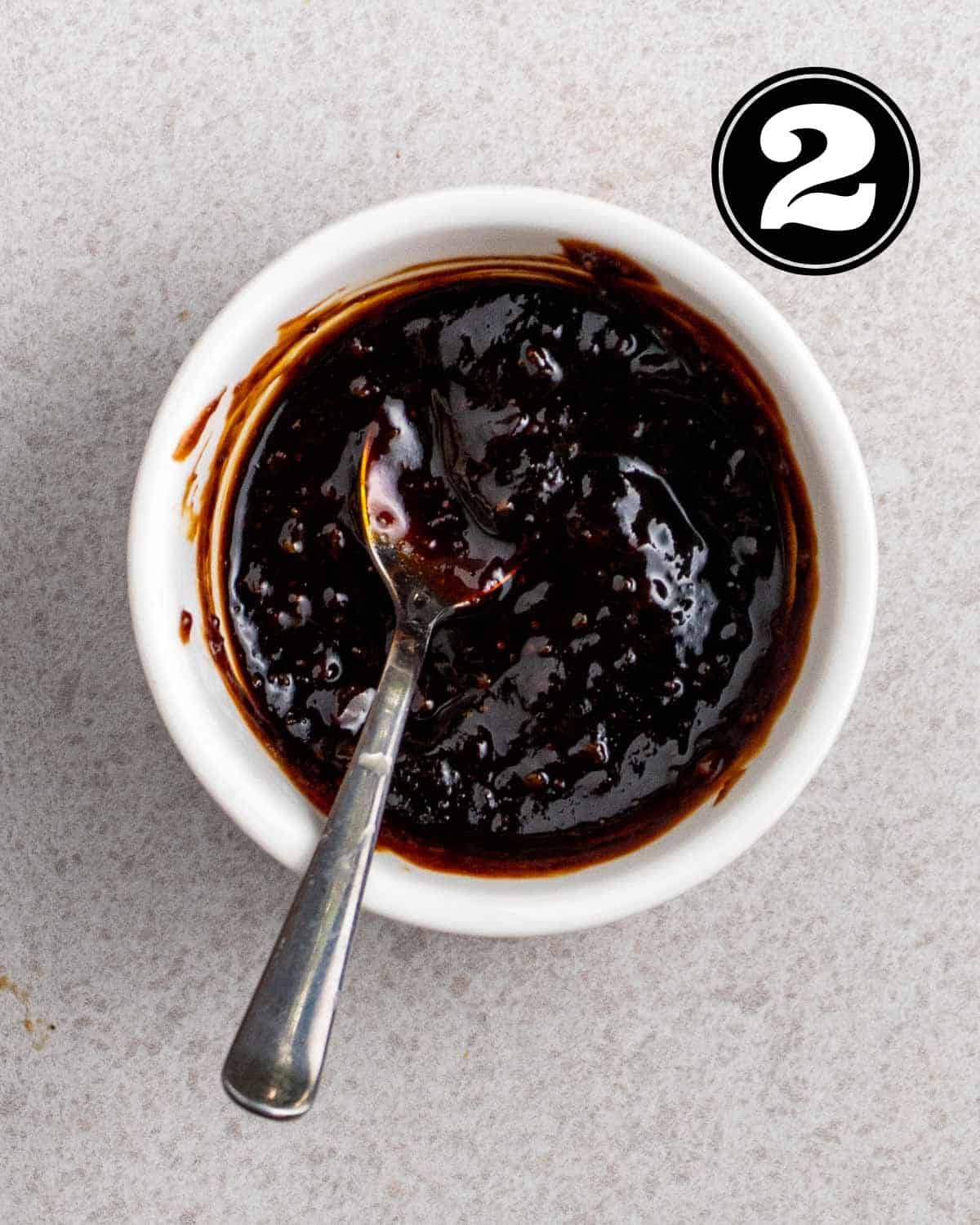 Stir-fry sauce in a ramekin with a teaspoon beside.