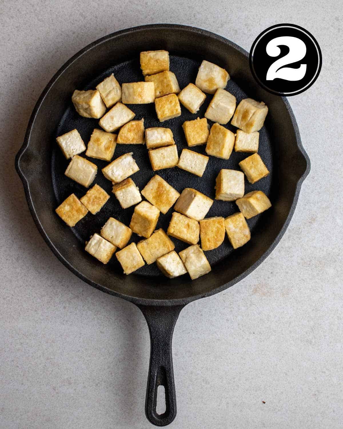 Pan fried tofu in a cast iron skillet.