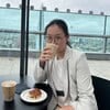Mee Sha drinking a cup of coffee seated.
