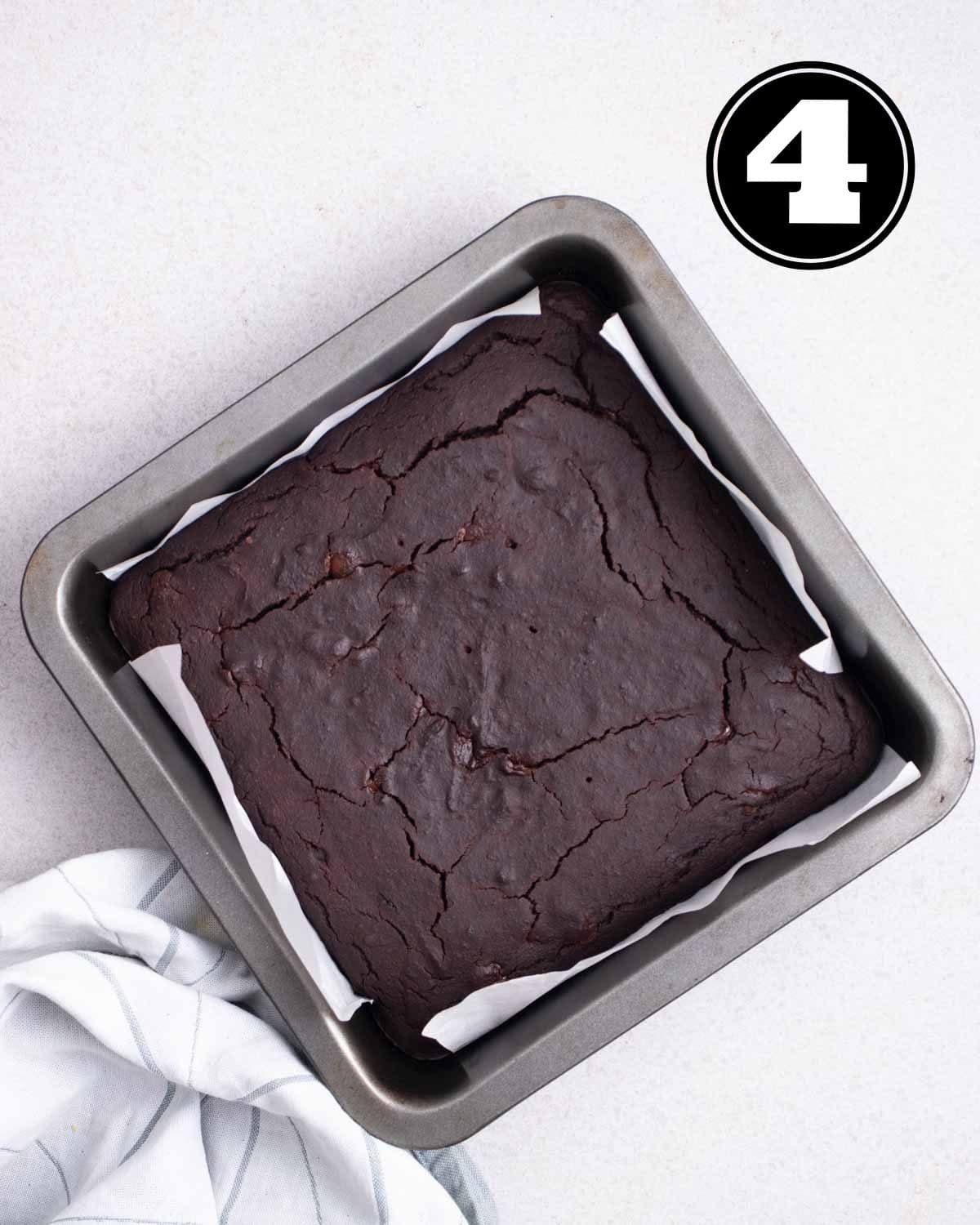Baked applesauce brownies in a square tray lined with parchment paper.