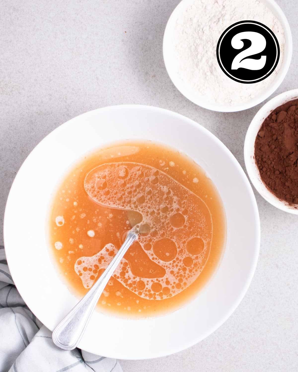 Wet ingredients in a white bowl with a fork beside.